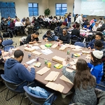 People at tables making crafts for community
